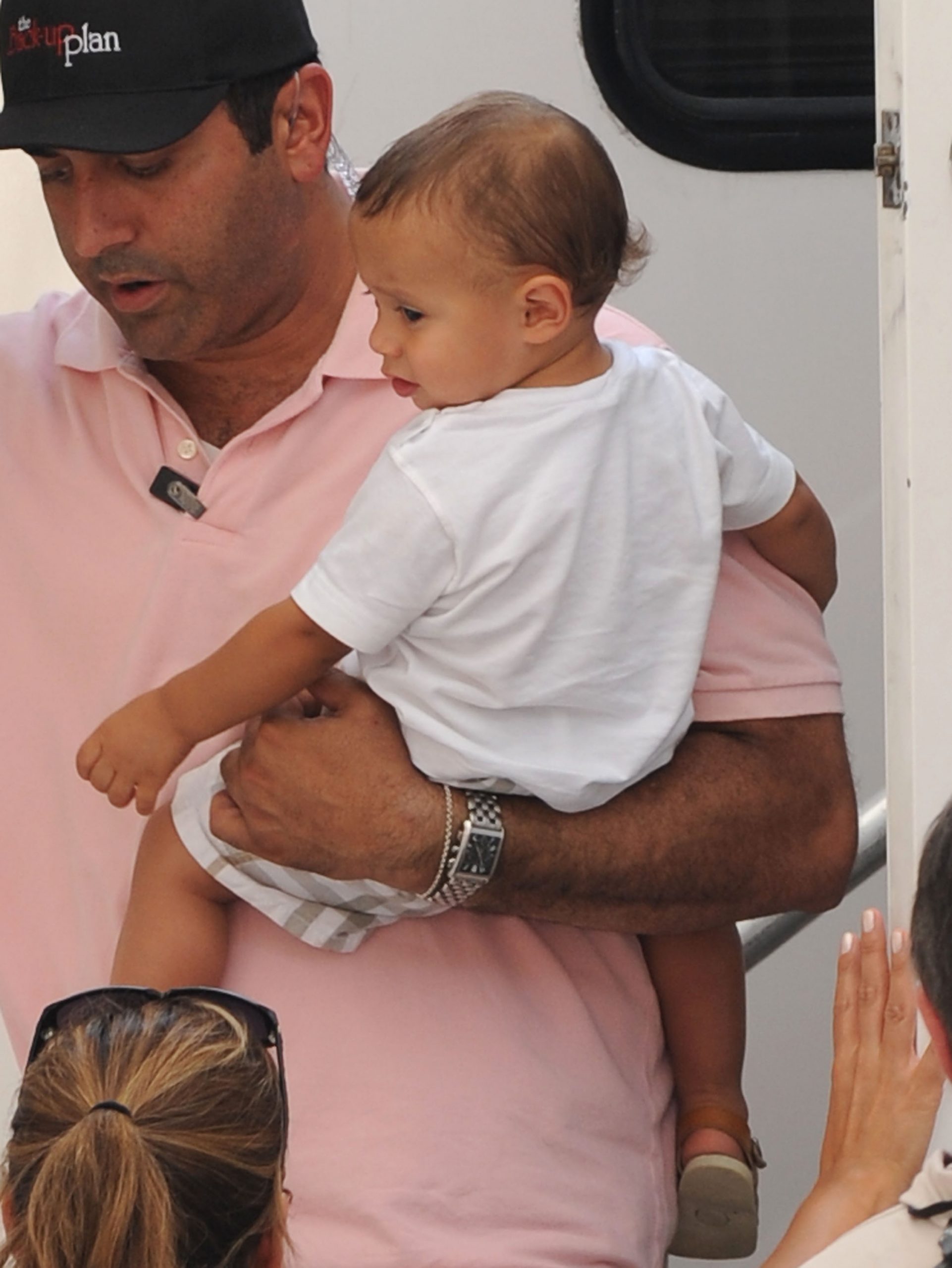 A bodyguard carries Jennifer Lopez's son, Maximilian 