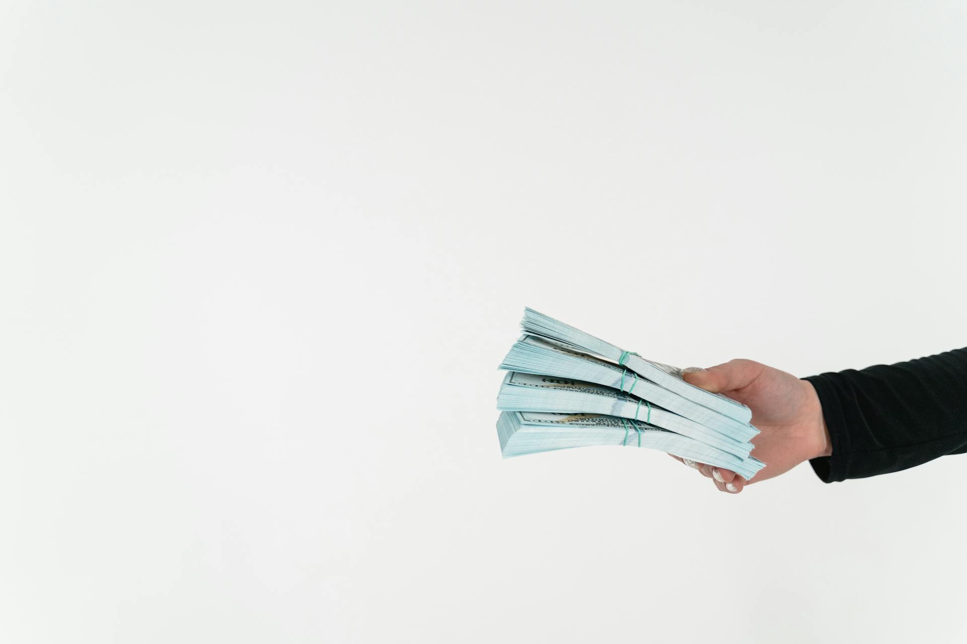 Close-up shot of a person holding bundles of money | Source: Pexels
