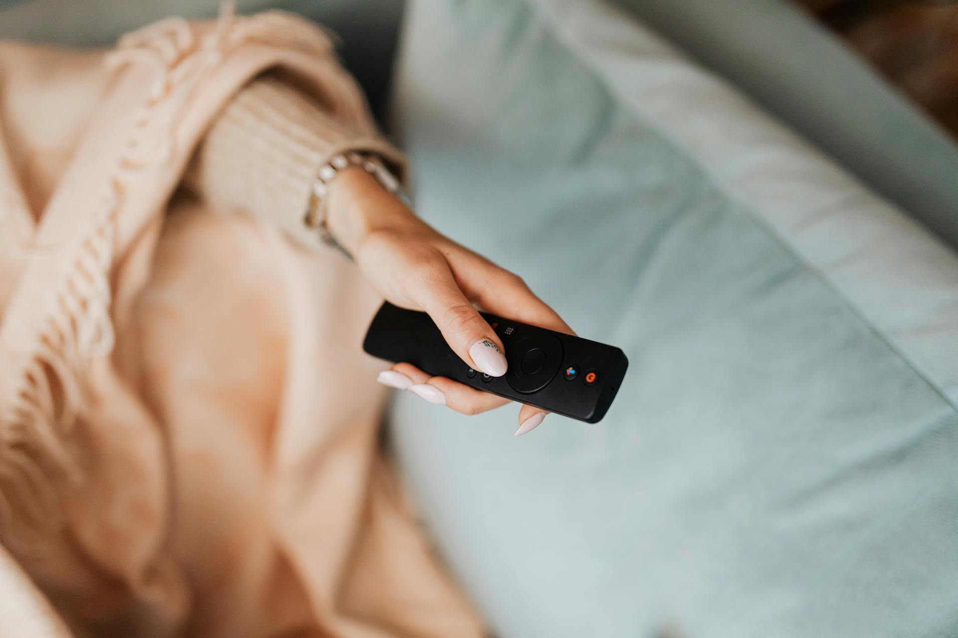 Close-up shot of a woman holding a remote control | Source: Pexels