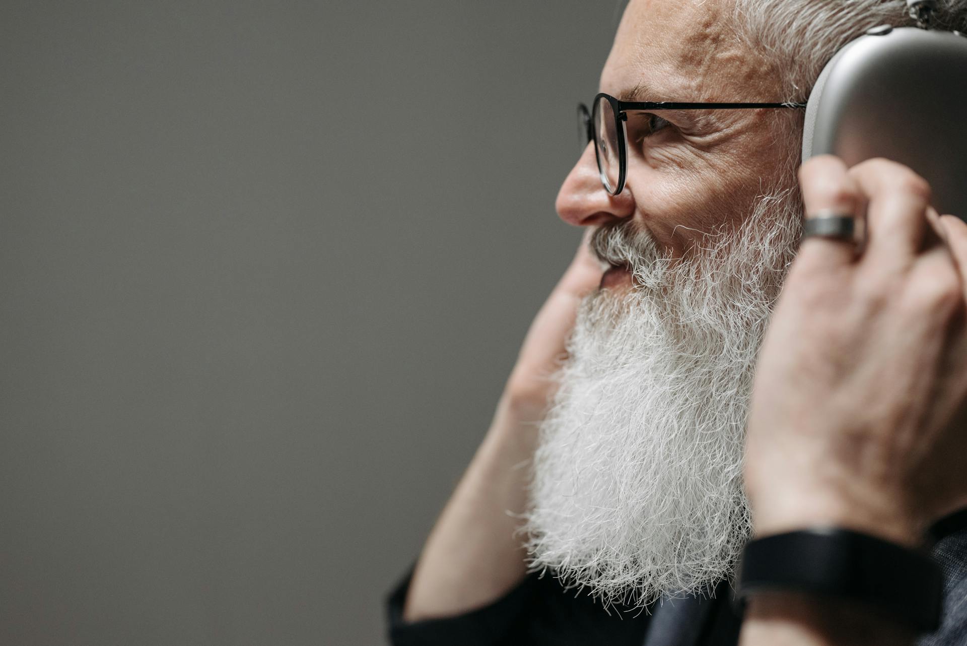 A smiling bearded man wearing headphones | Source: Pexels
