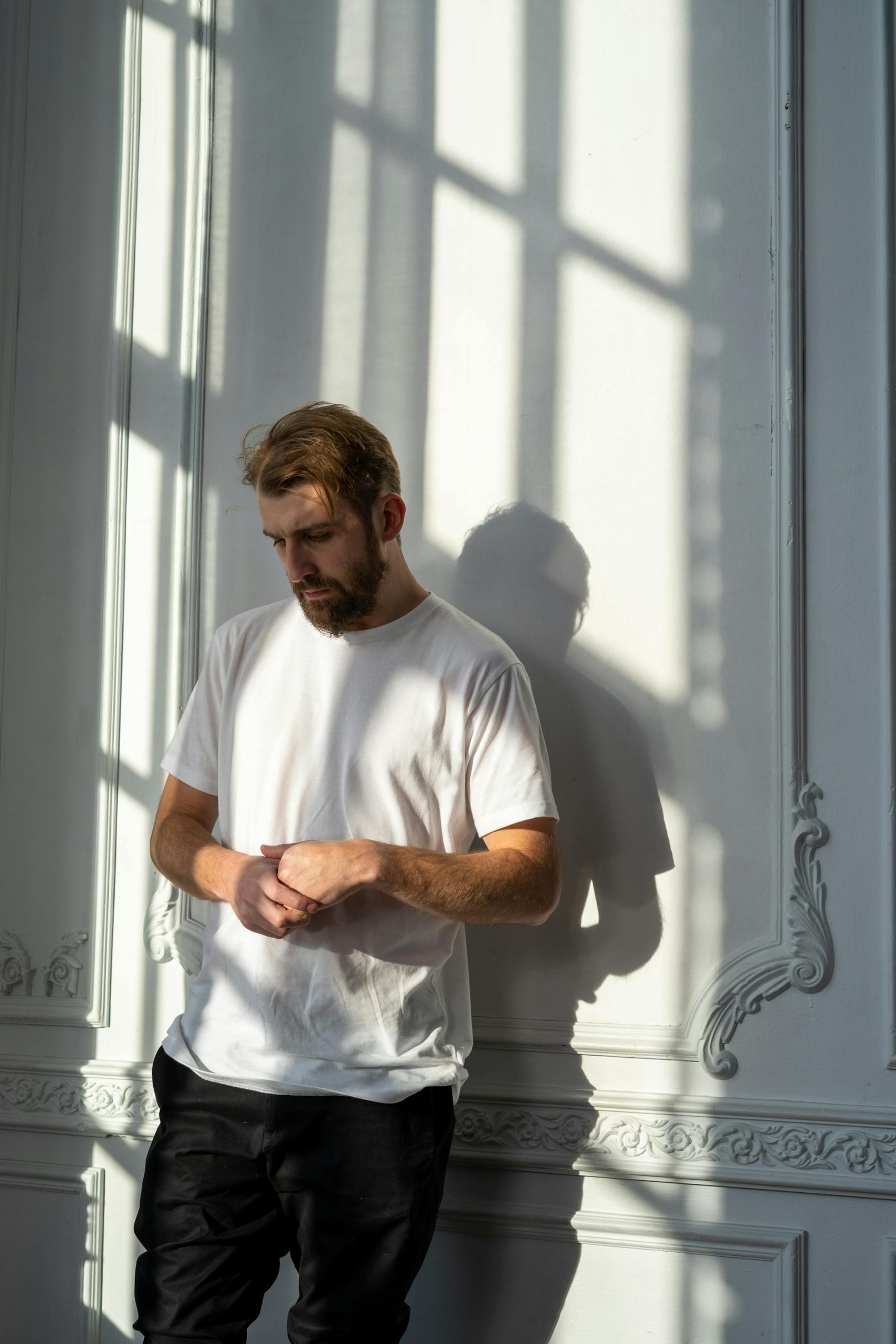 A thoughtful man leaning against the wall | Source: Pexels