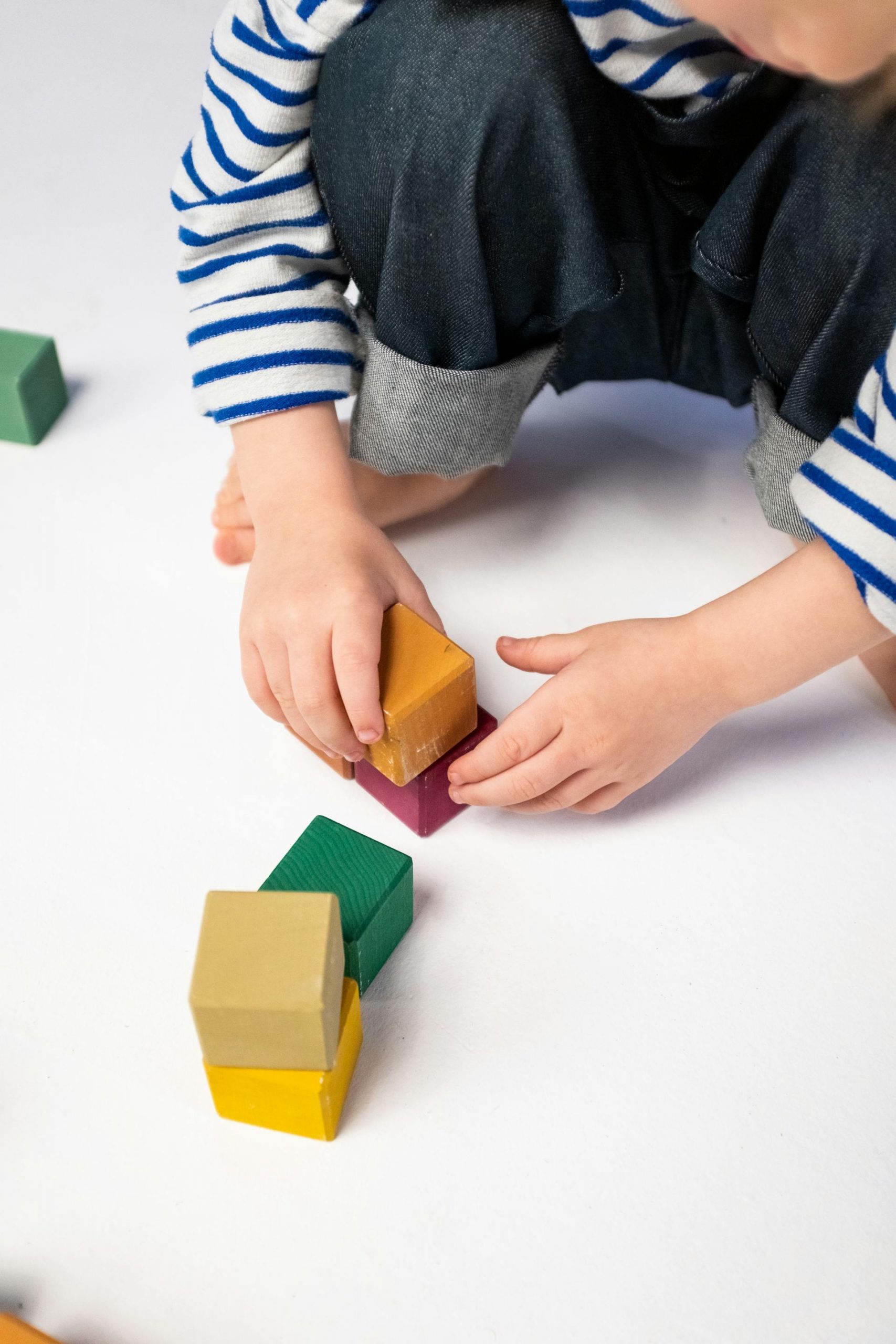 A close-up shot of a boy playing with plastic blocks | Source: Pexels
