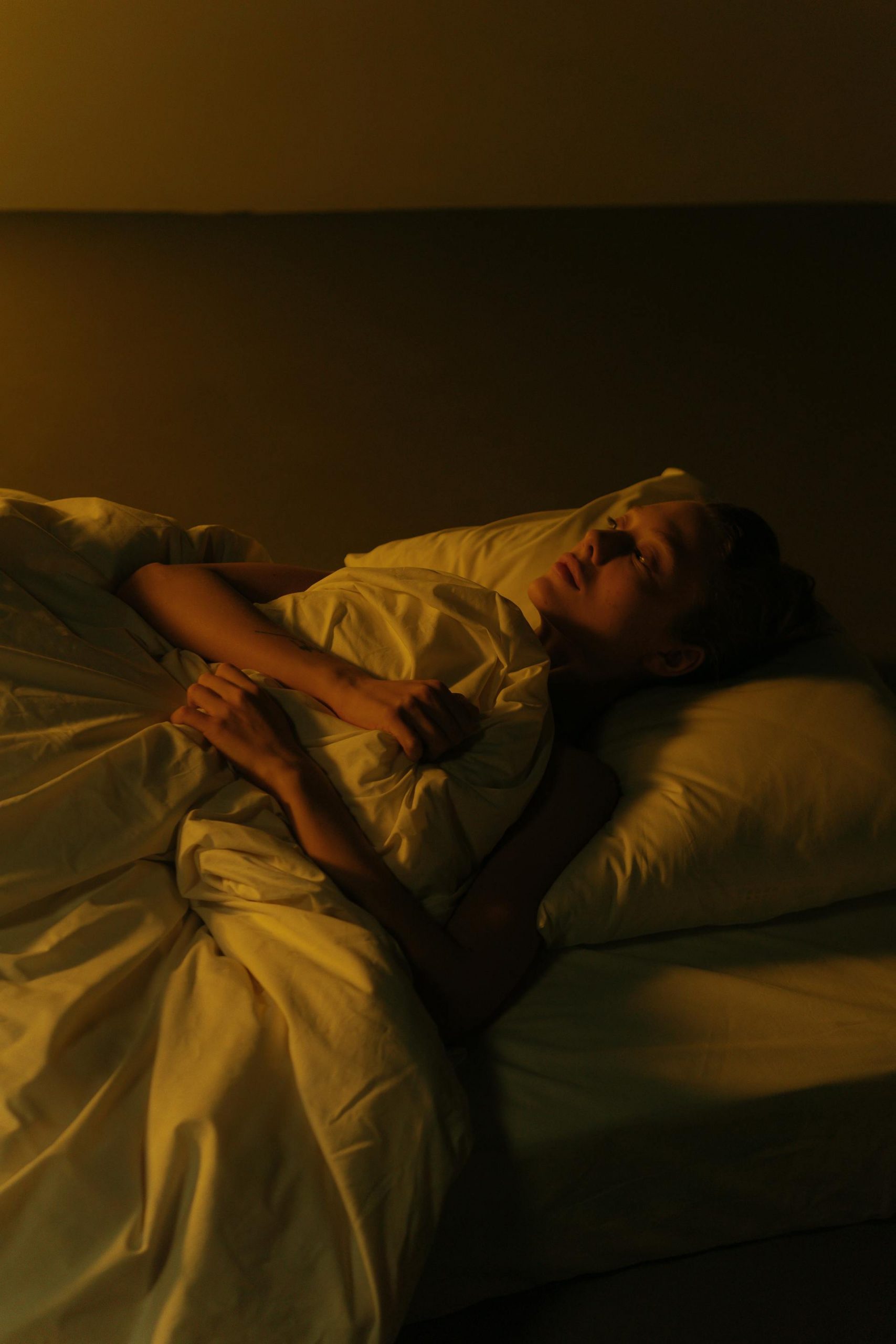 A woman lying awake in bed | Source: Pexels