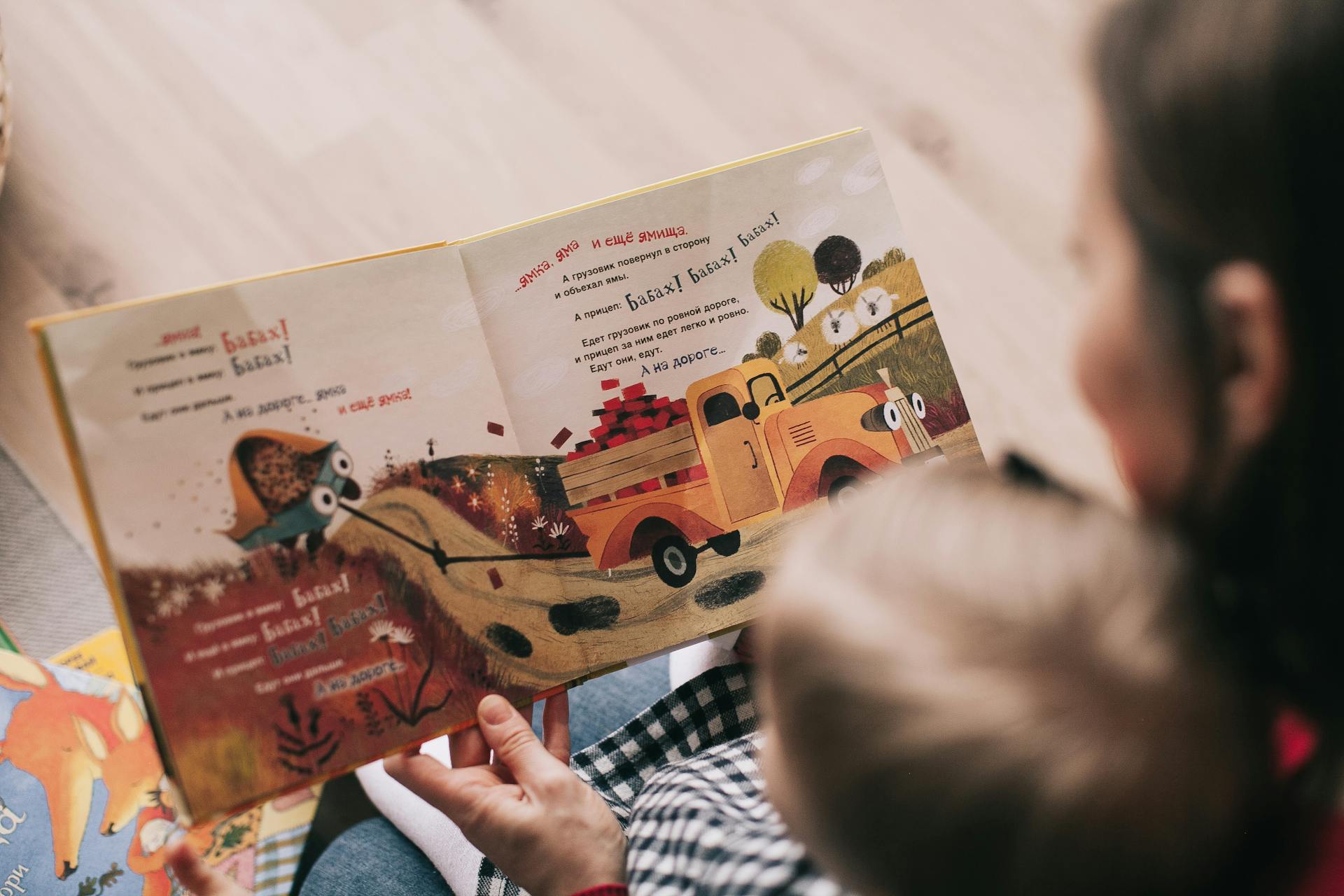 A woman reading a book to a toddler | Source: Pexels
