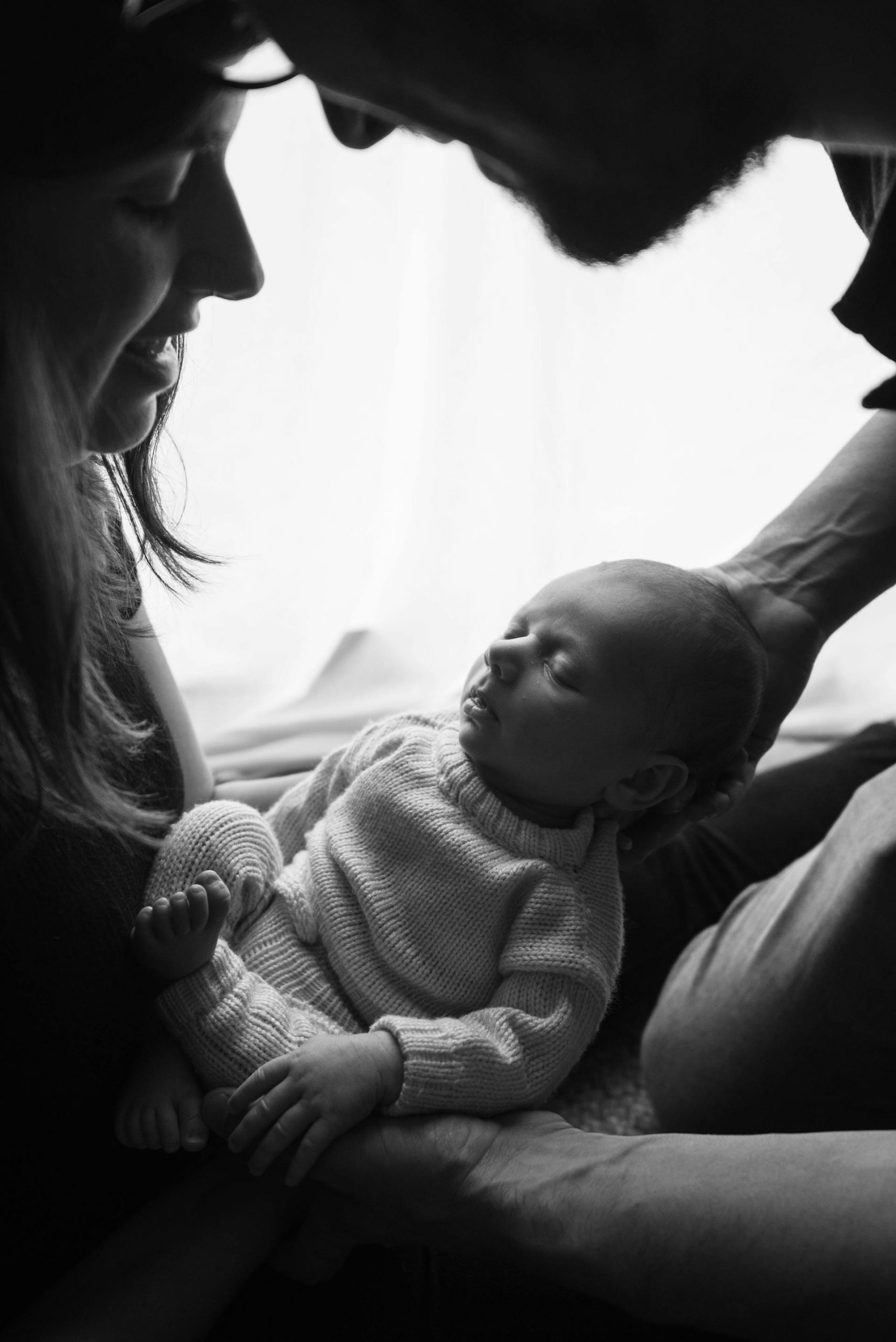 A grayscale photo of a couple holding a newborn baby | Source: Pexels