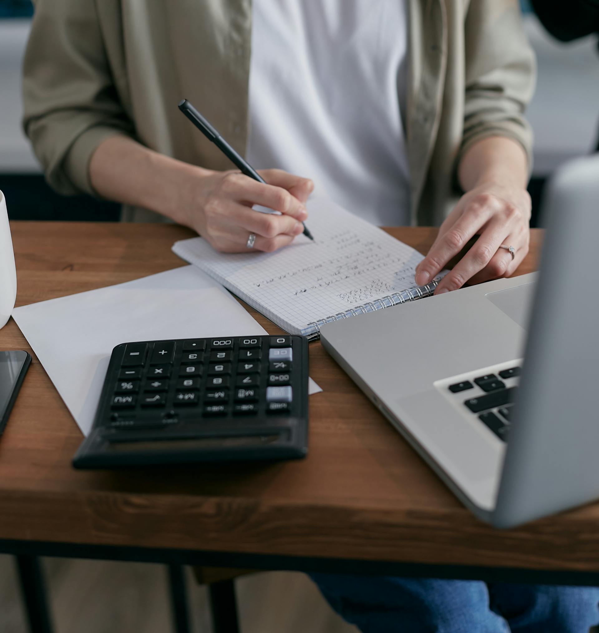 A close-up shot of a woman making calculations in a notepad | Source: Pexels