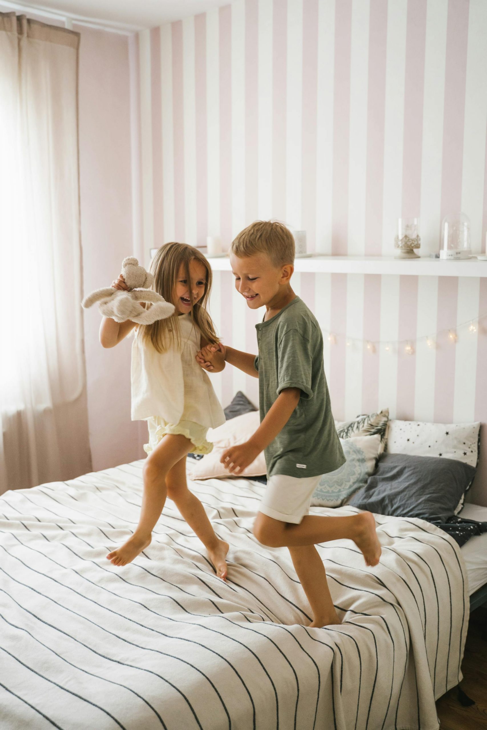 Happy kids dancing on the bed | Source: Pexels