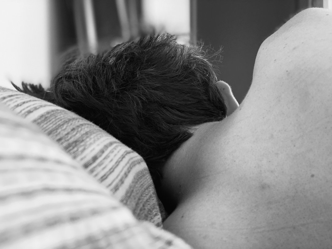 The rear view of a man sleeping in his bed | Source: Unsplash