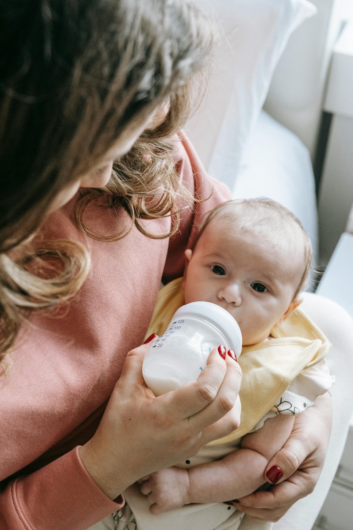 A woman feeding a baby | Source: Midjourney