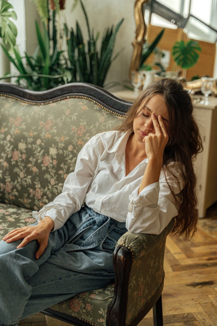 A tired woman sitting on a couch | Source: Pexels