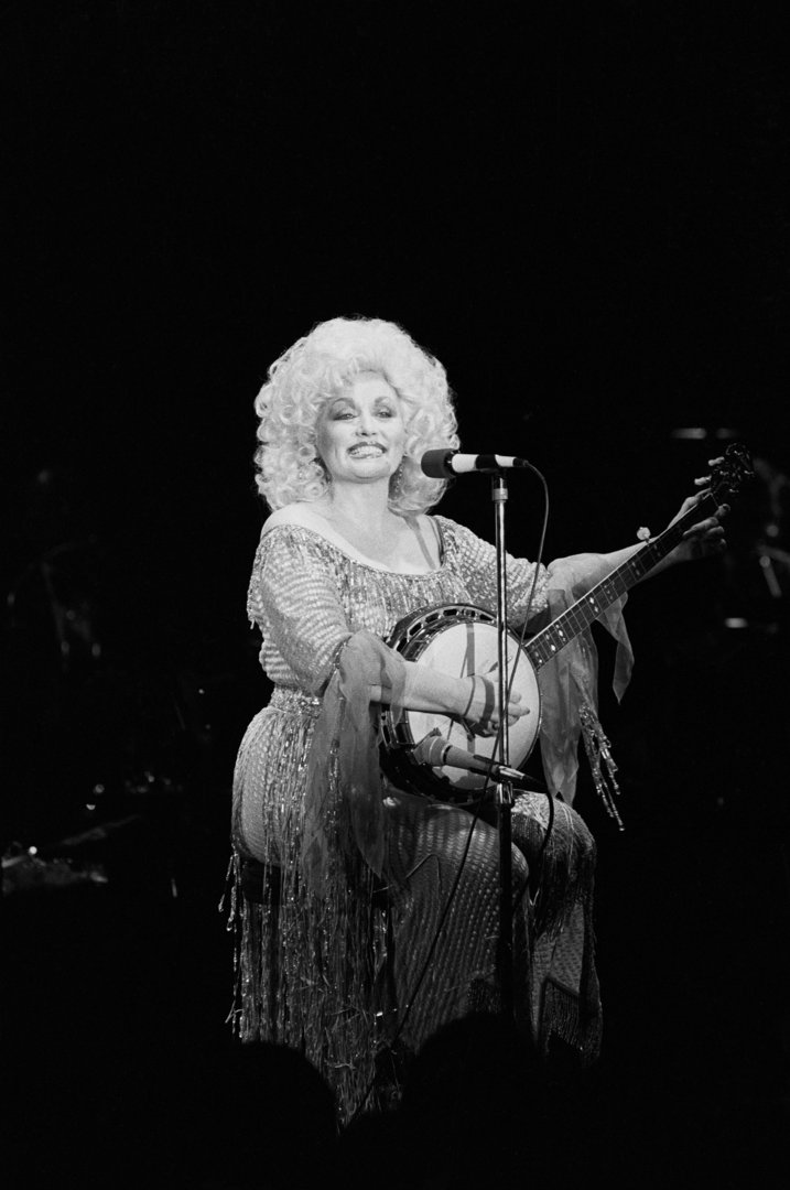 Dolly Parton playing a banjo during one of her past concerts in 1982. | Source: Getty Images