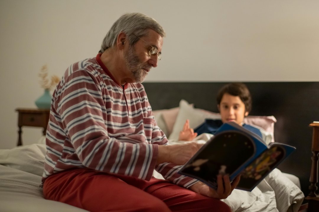 A man reading a book to a child | Source: Pexels