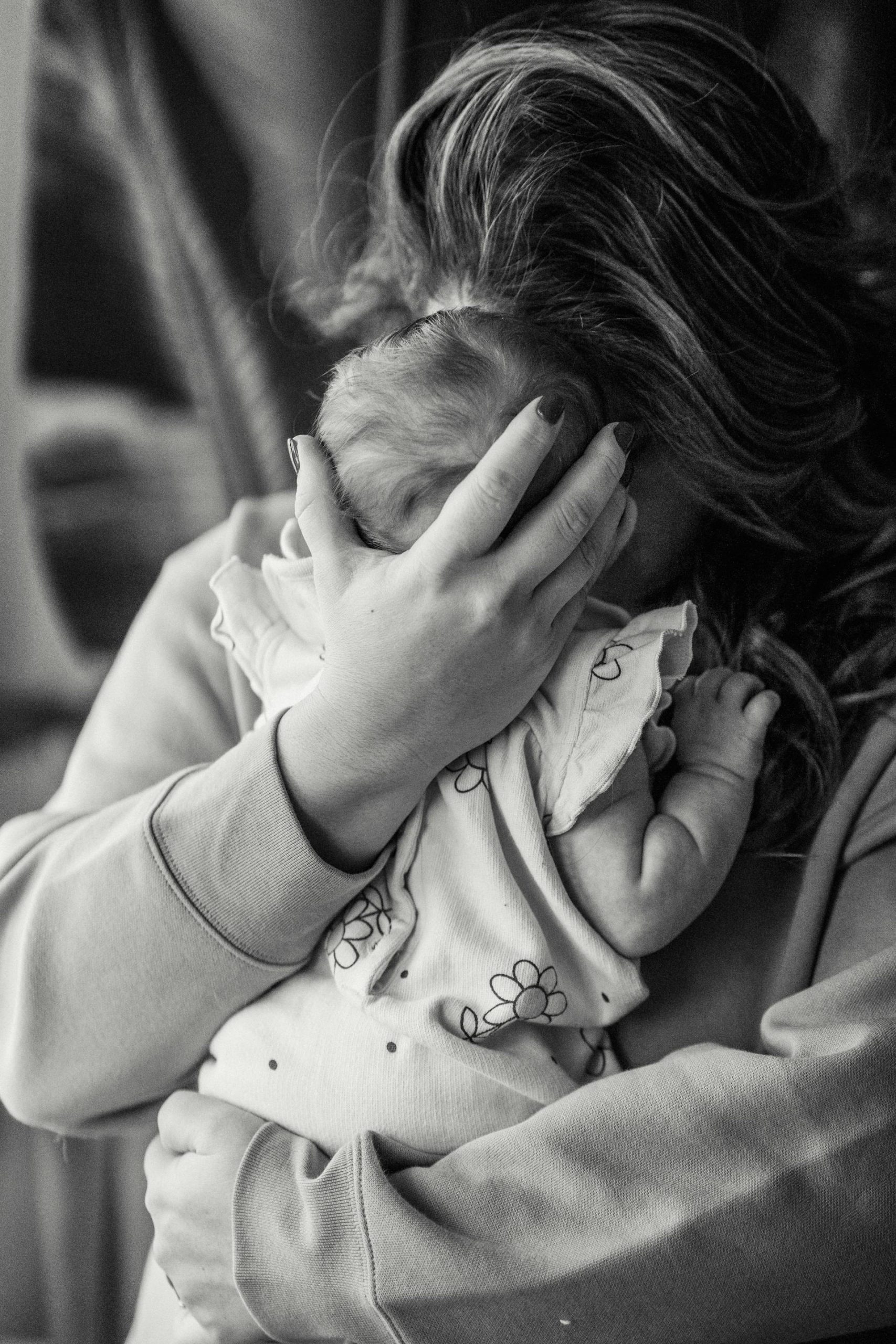 A grayscale photo of a woman hugging her baby | Source: Pexels