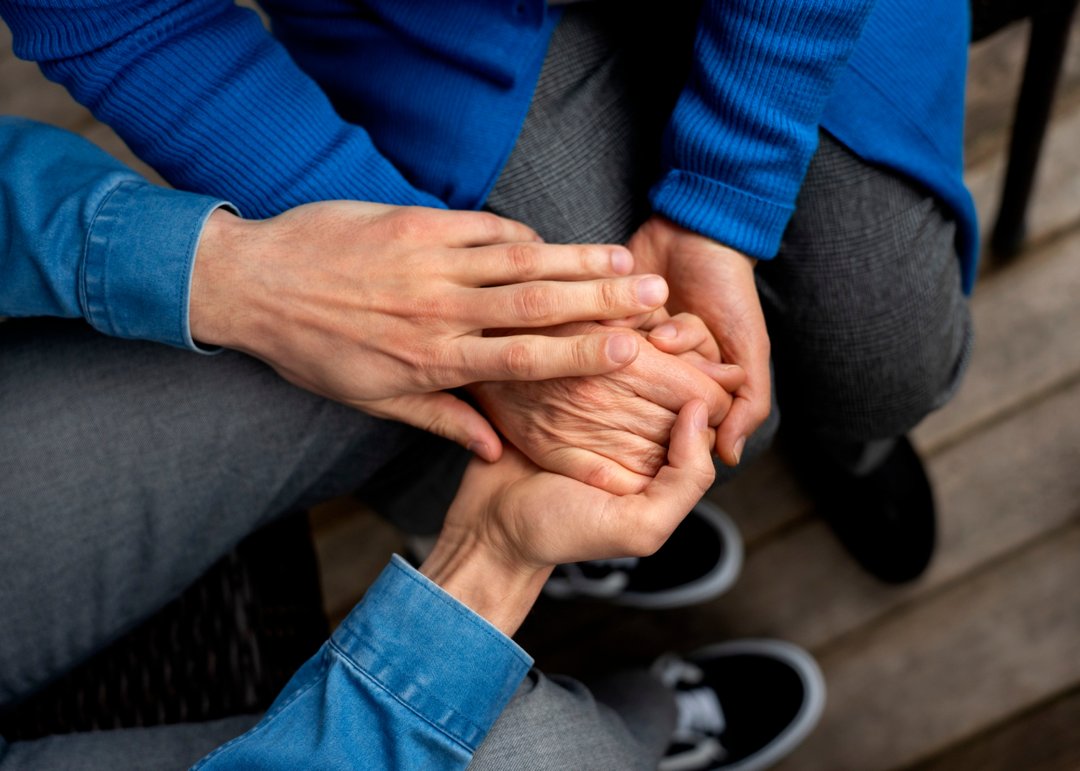 A young man holding an elderly woman's hand | Source: Freepik
