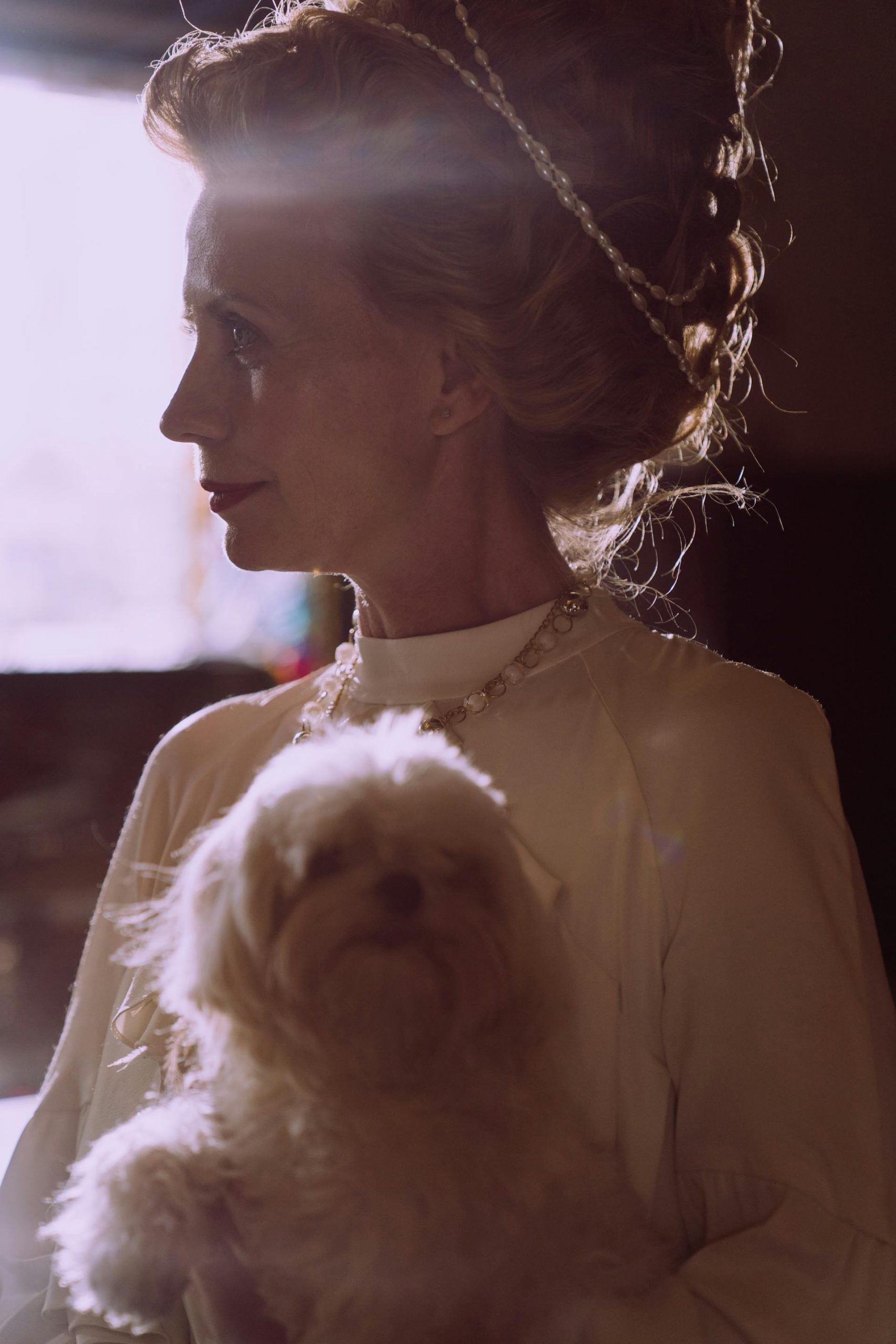 A middle-aged woman holding a dog | Source: Pexels