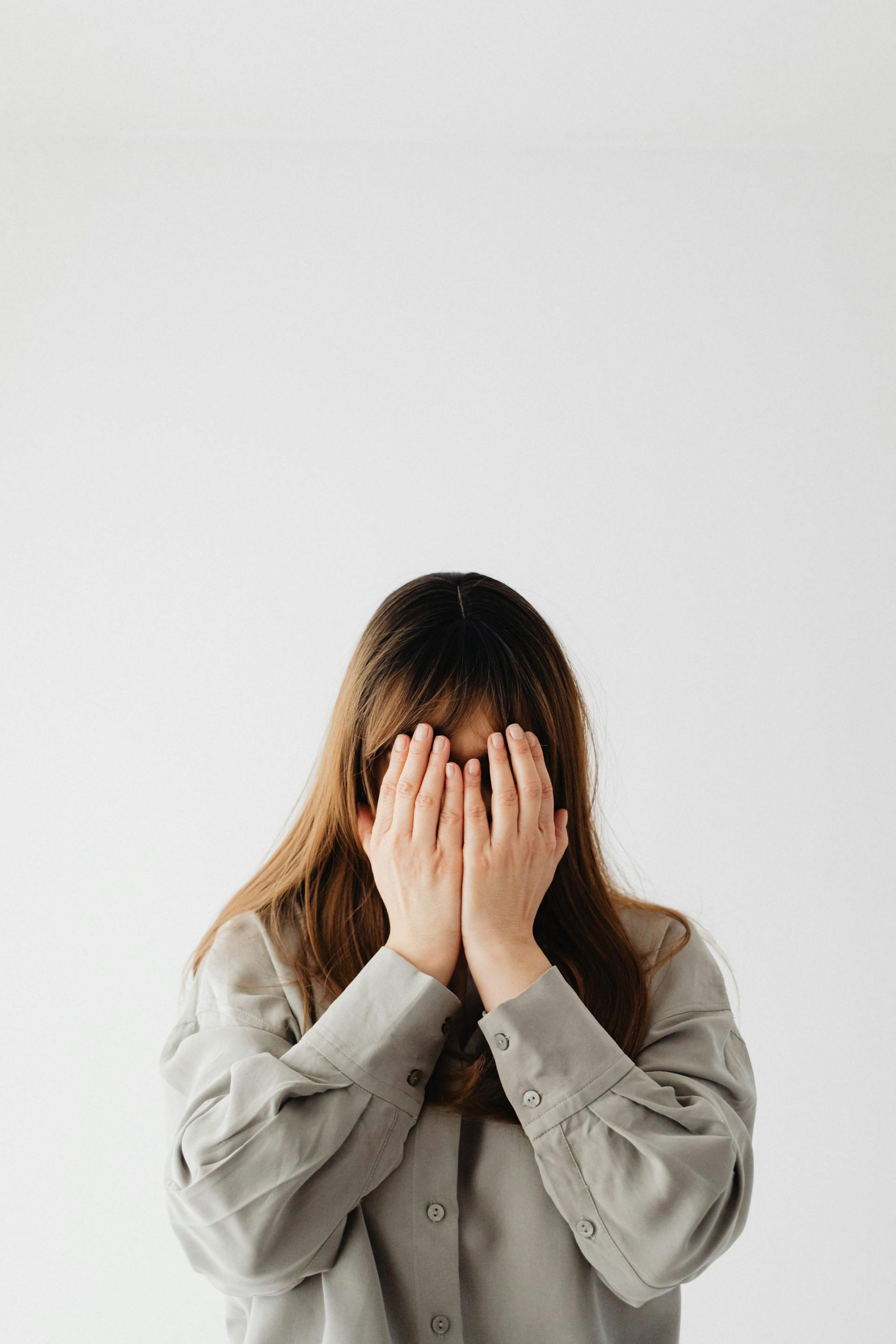 A woman covering her face with her hands | Source: Pexels