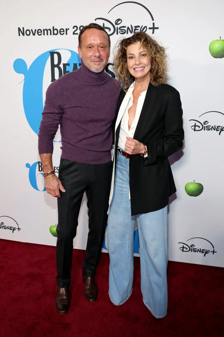 Faith Hill goes retro-chic in a boxy blazer and wide-leg jeans while Tim McGraw opts for a rich plum turtleneck at the