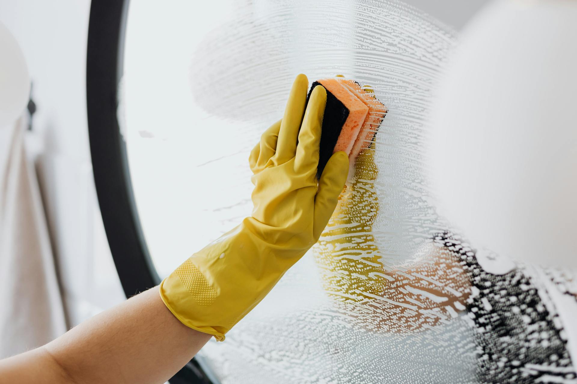 A woman cleaning a mirror | Source: Pexels