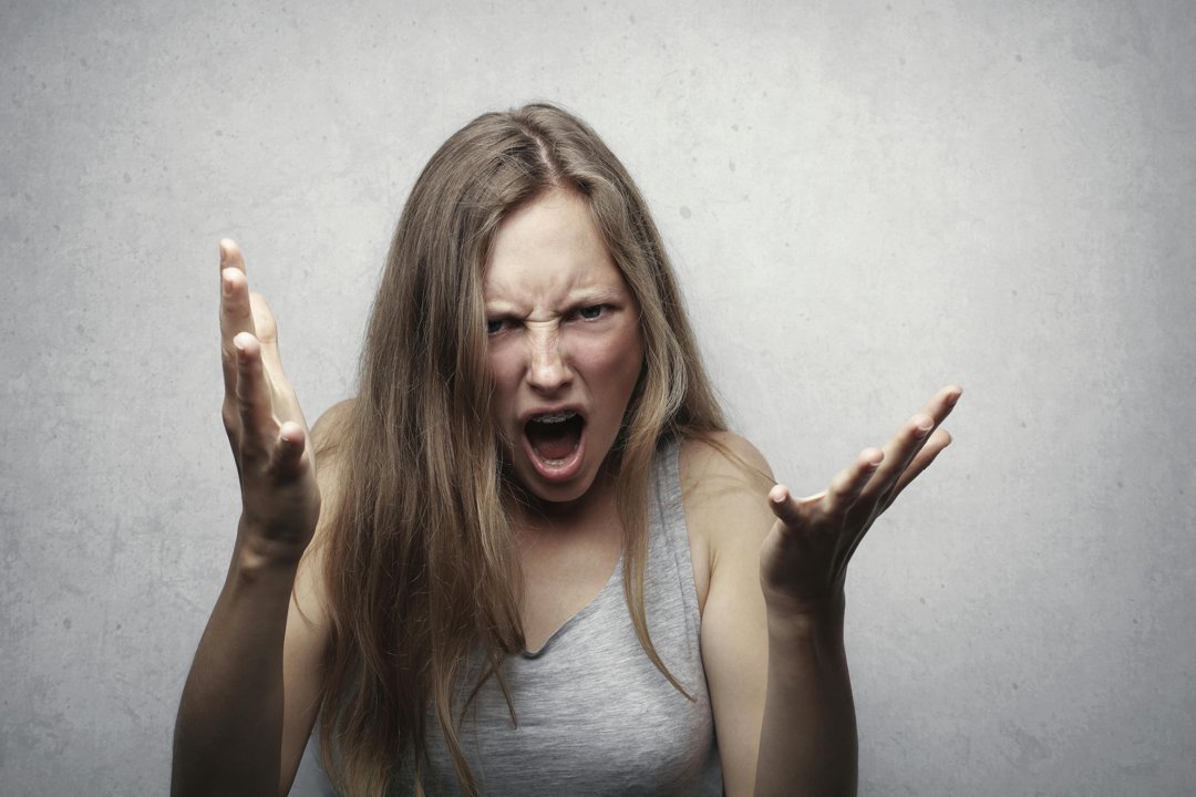 An angry woman with her arms raised | Source: Pexels