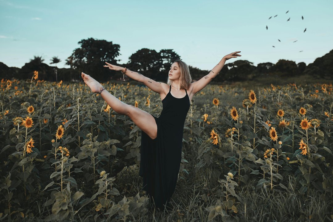 A woman dancing among flowers | Source: Pexels