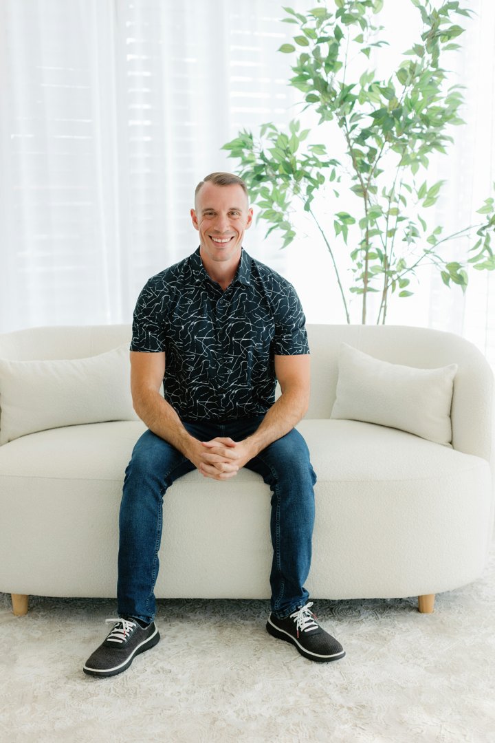 A smiling man sitting on a couch | Source: Unsplash