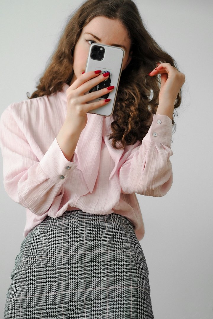A young woman holding her phone | Source: Unsplash