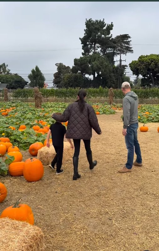 Meghan Markle, Prince Harry, and their son Prince Archie are pictured walking through a pumpkin patch, dated October 26, 2025 | Source: Instagram/meghan