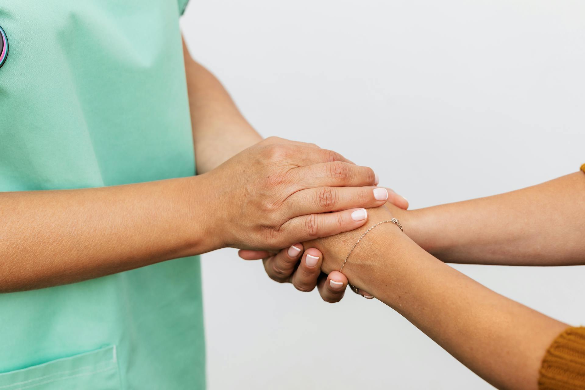 A nurse holding a woman's hands | Source: Pexels