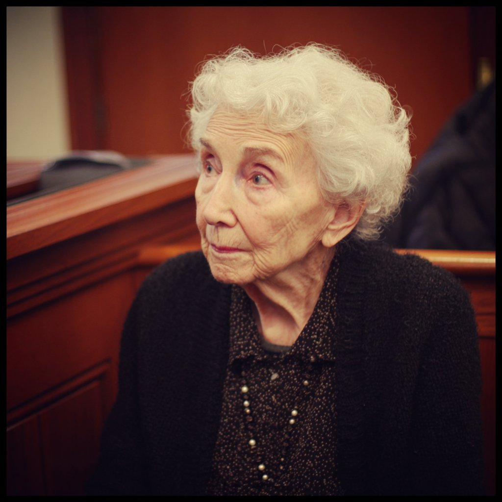 An old woman sitting in a courtroom | Source: Midjourney