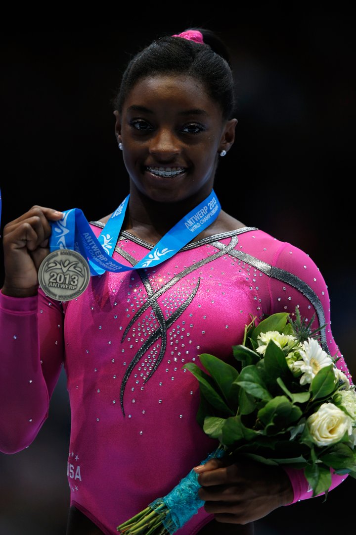 A 16-year-old Biles clutches her bronze medal with pride after placing in the women’s balance beam final at the 2013 Artistic Gymnastics World Championships in Antwerp, Belgium. This marked the beginning of her meteoric rise as one of the most celebrated athletes in gymnastics history.
