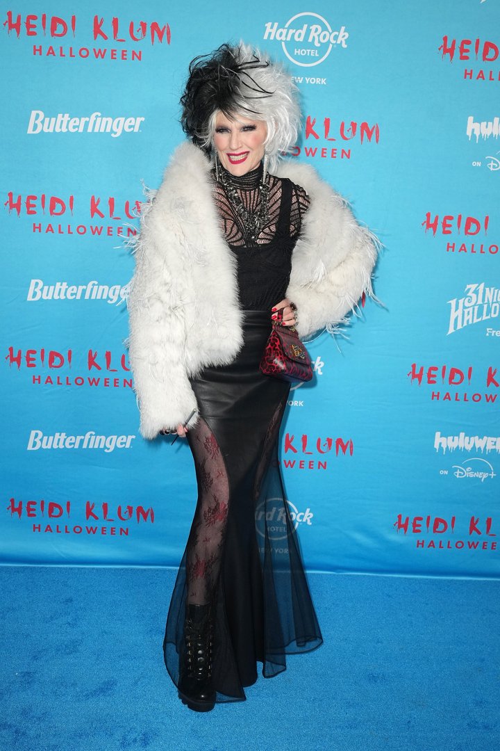 Also at Heidi Klum's 24th Annual Halloween Party, Elon Musk's mother, Maye Musk, embraced full villain mode in a glam Cruella de Vil-inspired look. She wore a voluminous black-and-white wig, a dramatic fur coat style with feathers, and a sheer black gown layered over printed tights. The outfit was finished with lace-up platform boots, a red animal-print handbag, and a statement necklace, delivering high fashion with a mischievous twist.