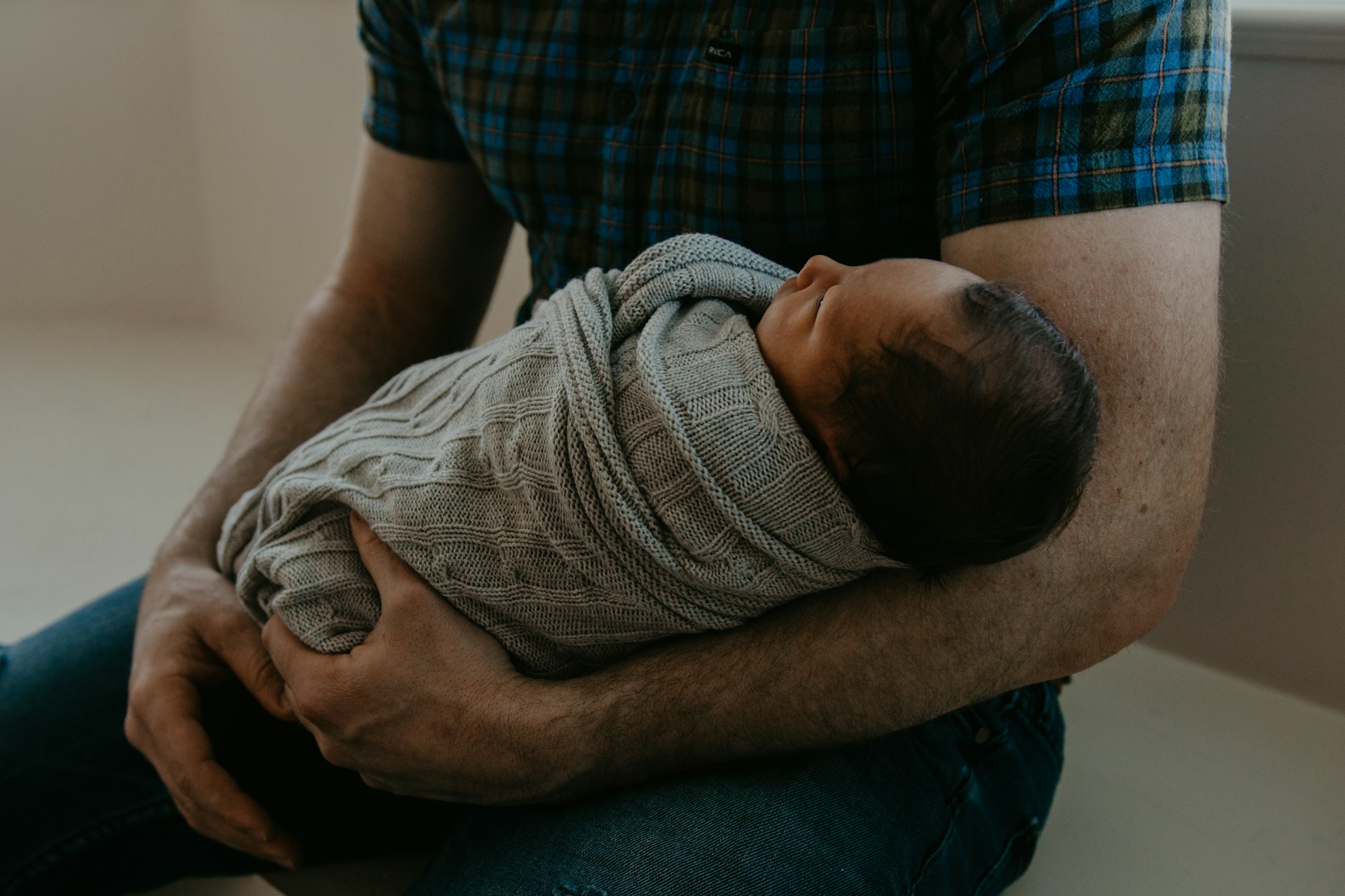 A man holding a newborn baby | Source: Unsplash