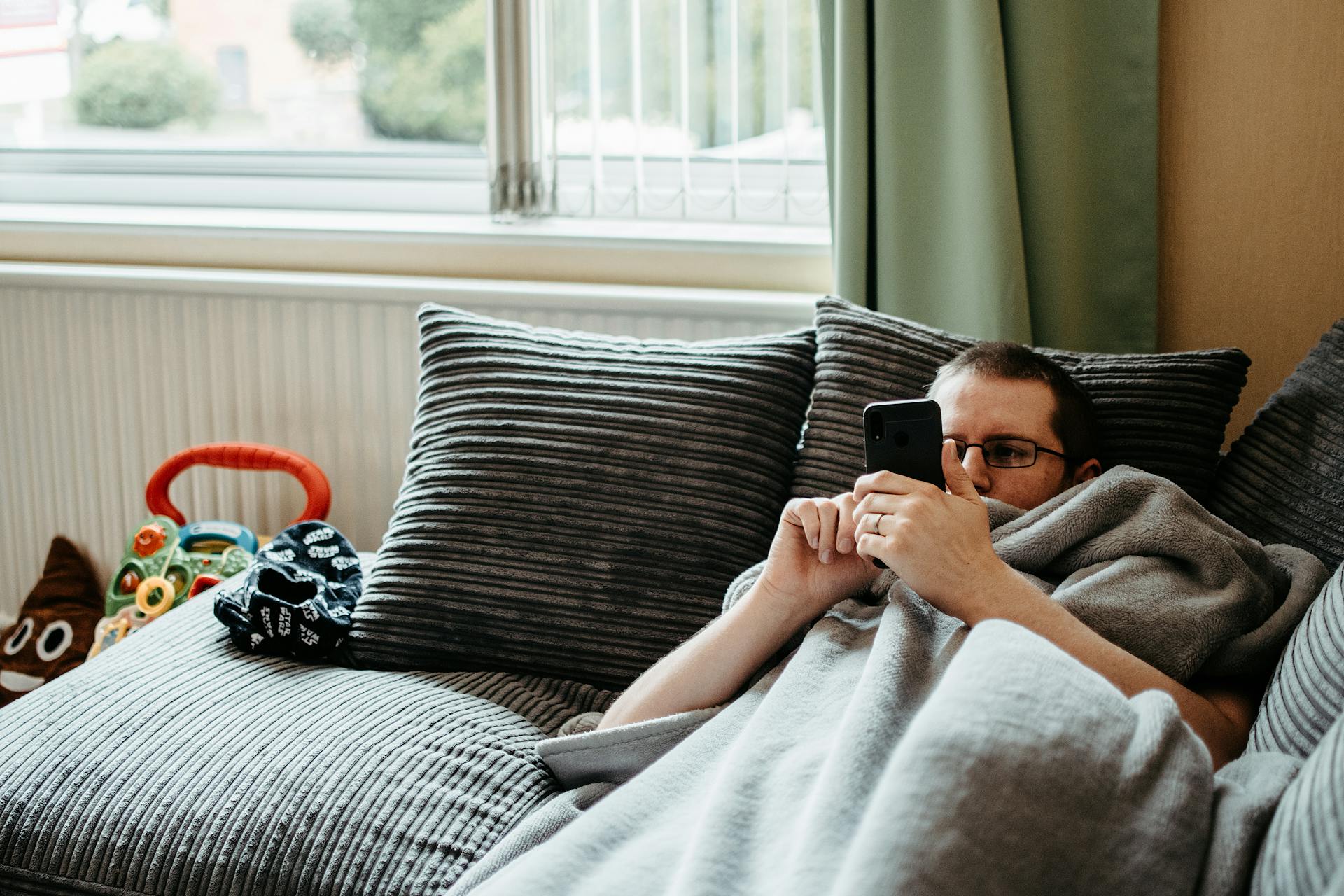 A man lying on the couch and using his phone | Source: Pexels