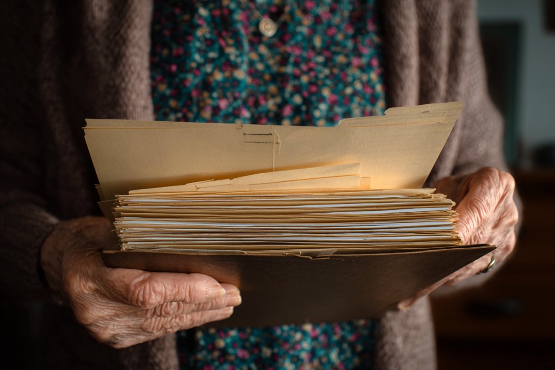 An older woman holding a folder | Source: Midjourney