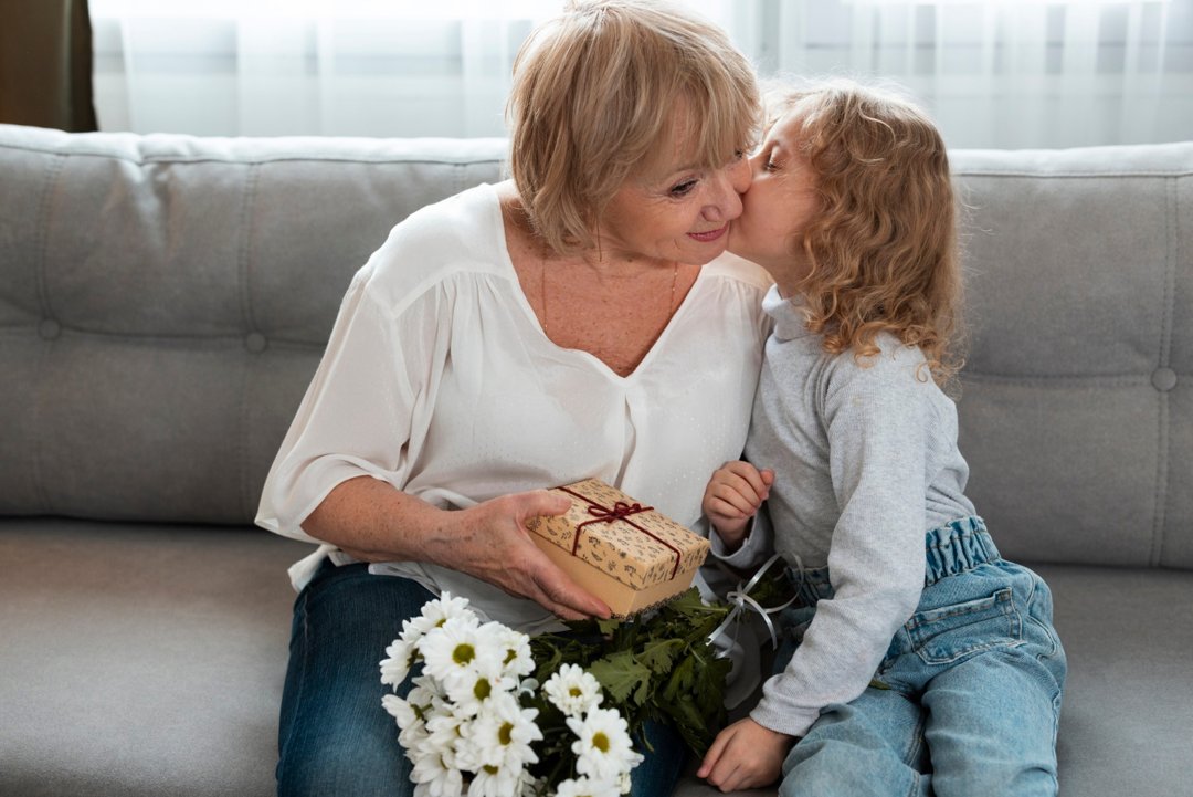 A granddaughter kissing her grandmother on the cheek | Source: Freepik