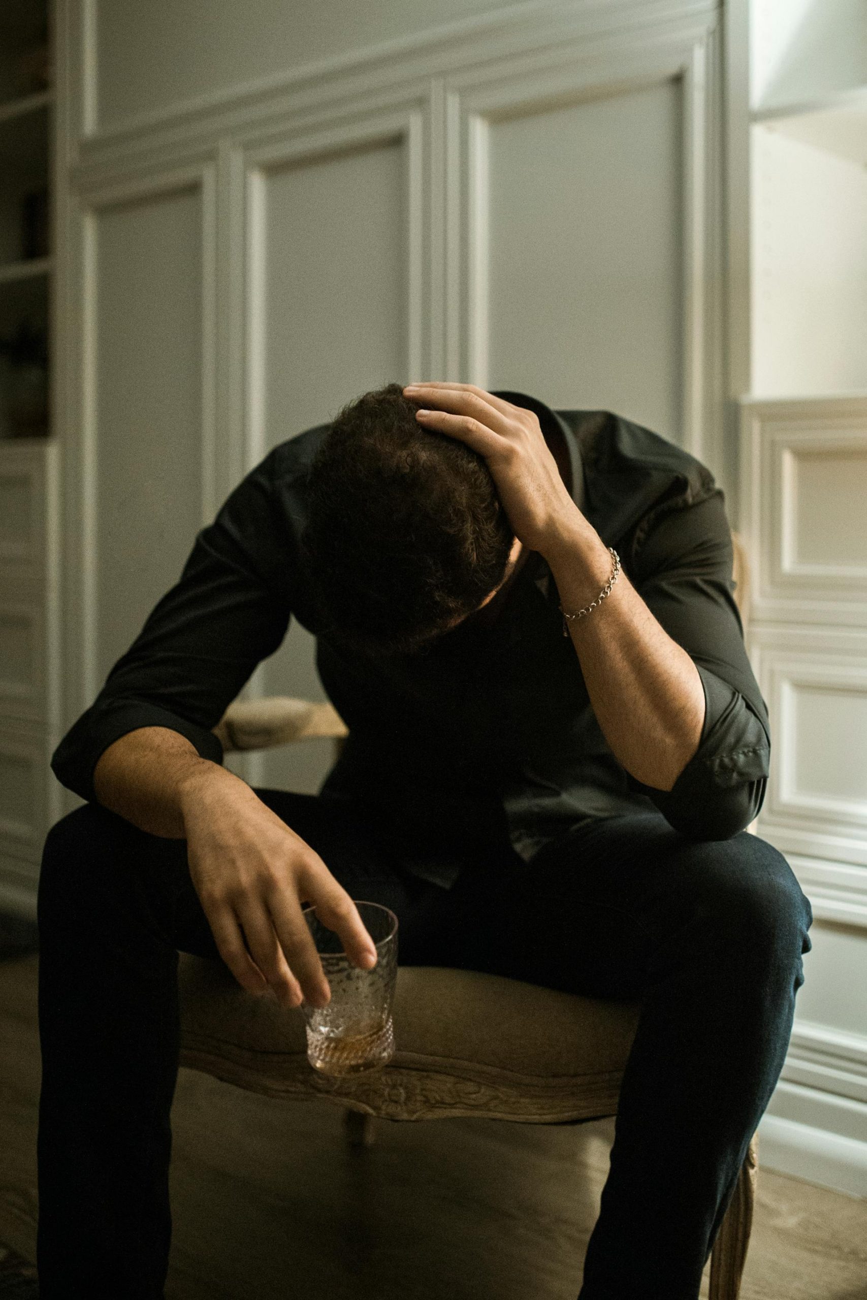 A depressed man sitting alone with a glass of drink | Source: Pexels