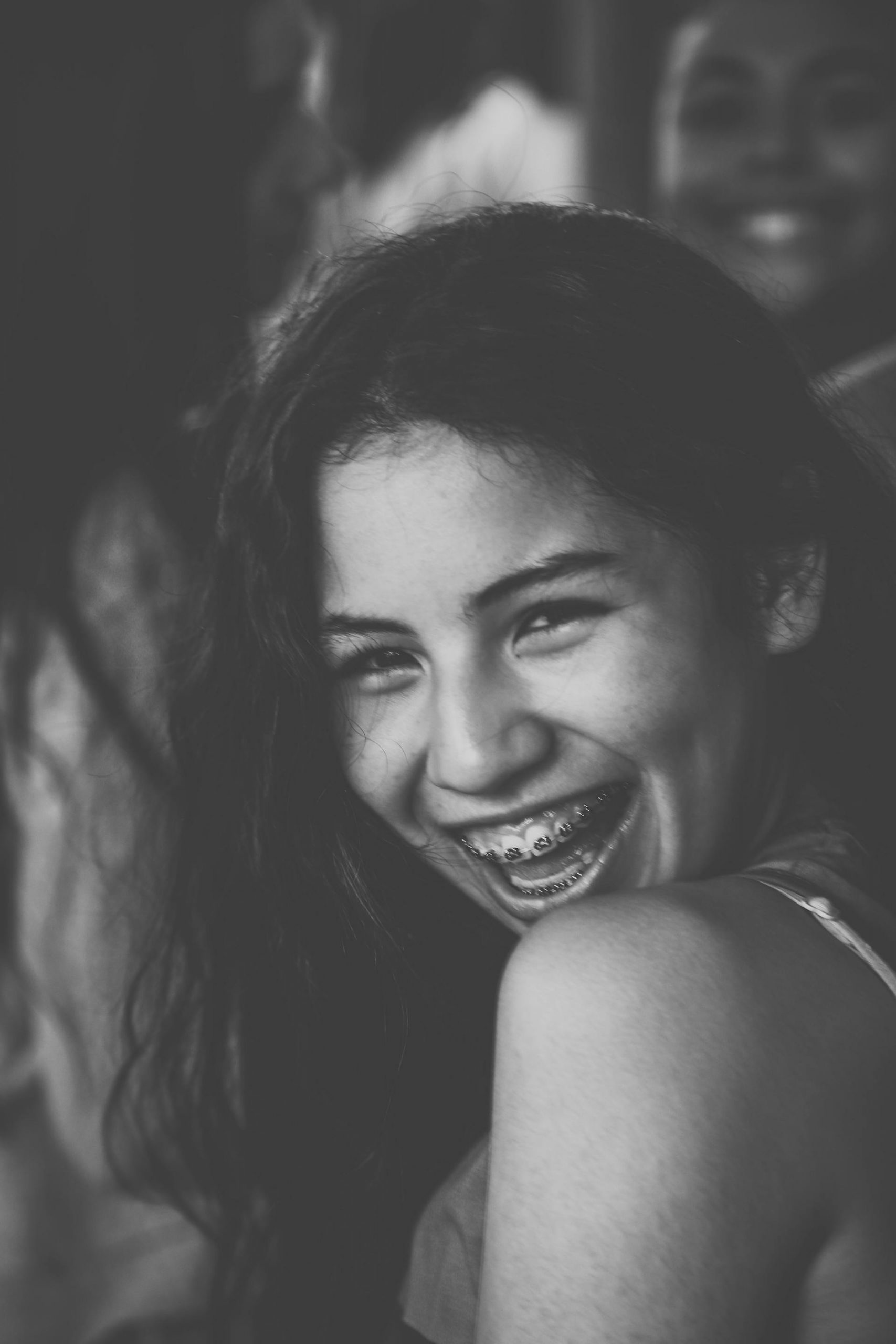 Grayscale photo of a smiling young woman with braces | Source: Pexels