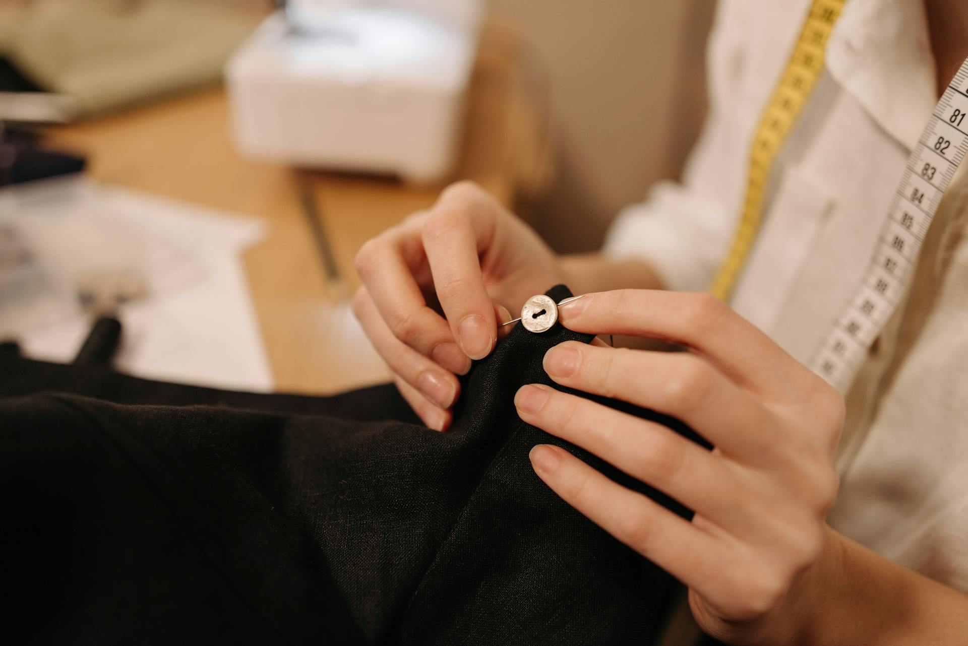 A woman sewing a button | Source: Pexels