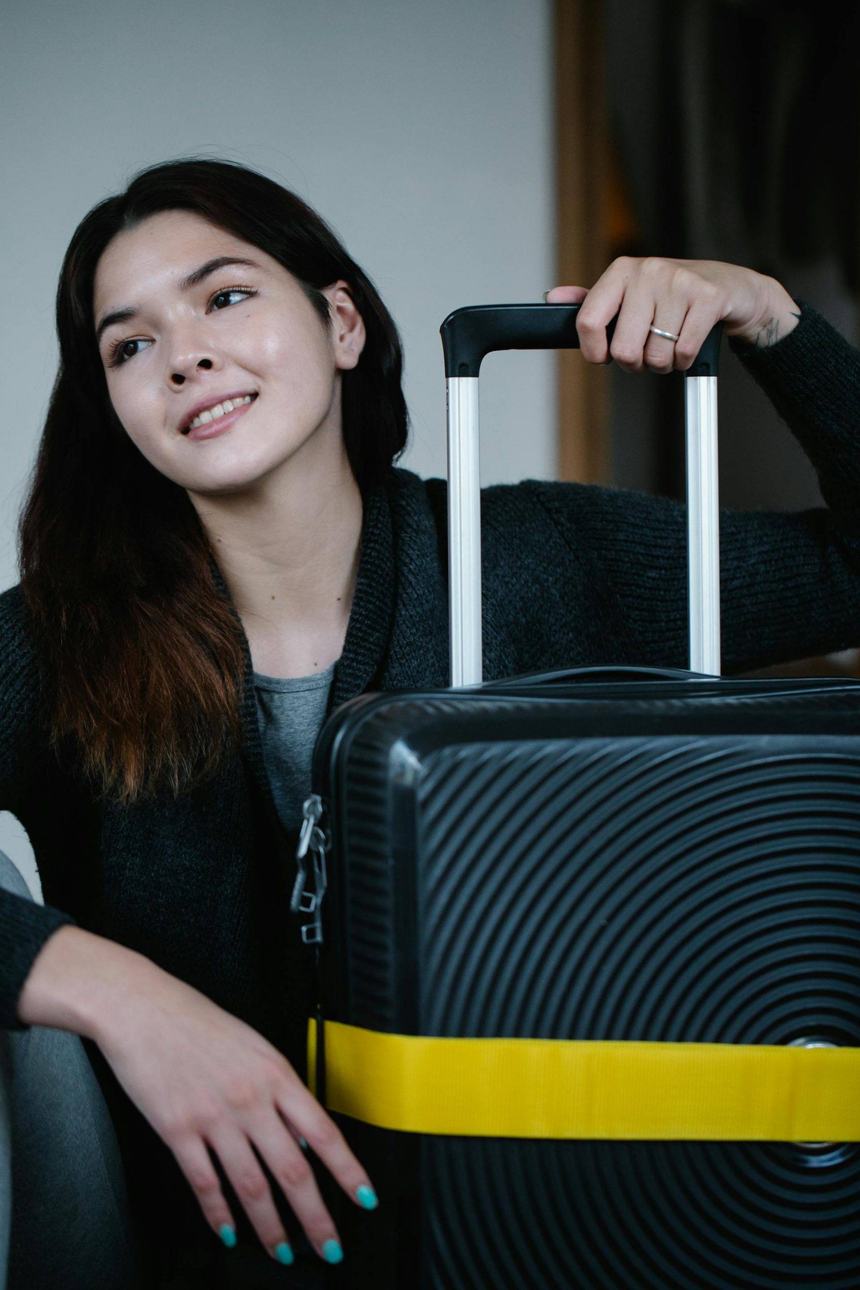 A happy woman with a piece of luggage | Source: Pexels