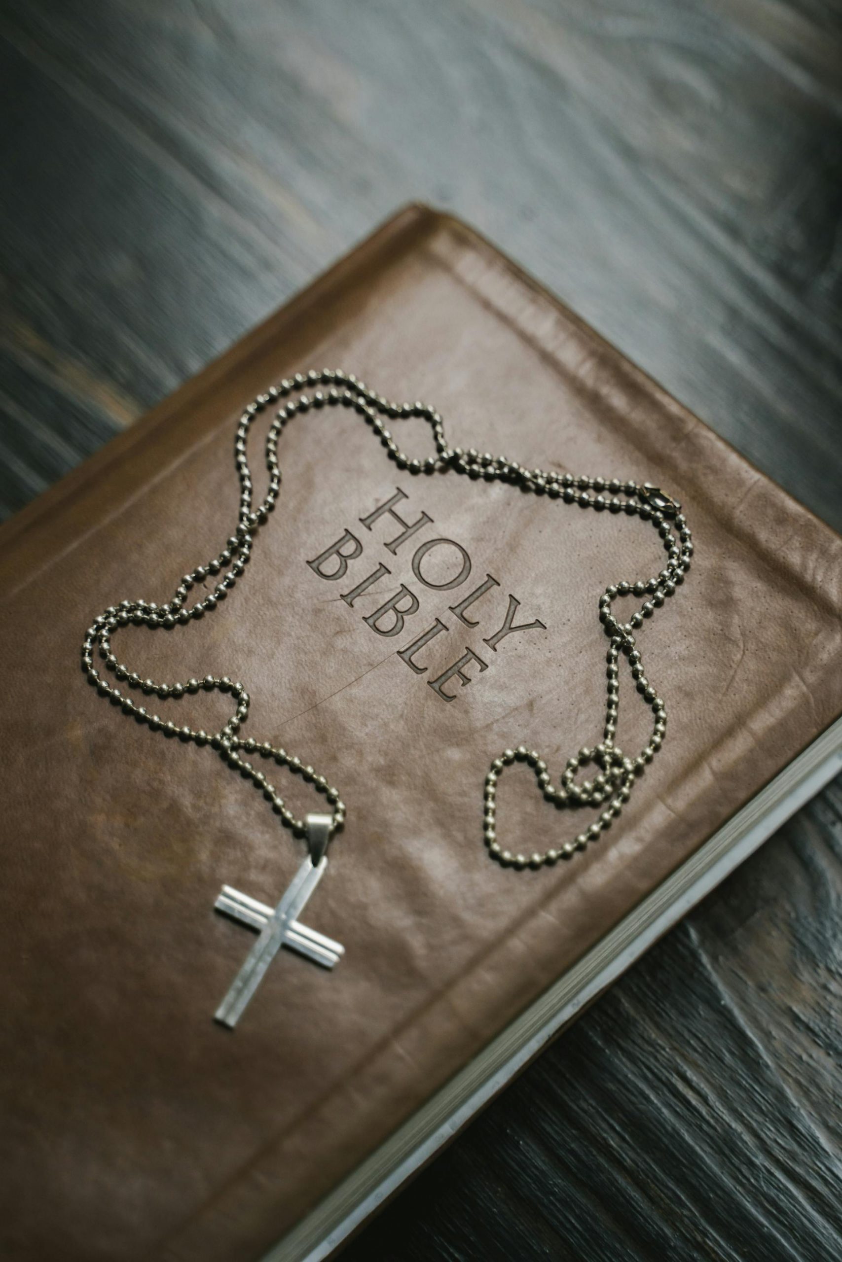 A Bible and a silver cross necklace | Source: Pexels