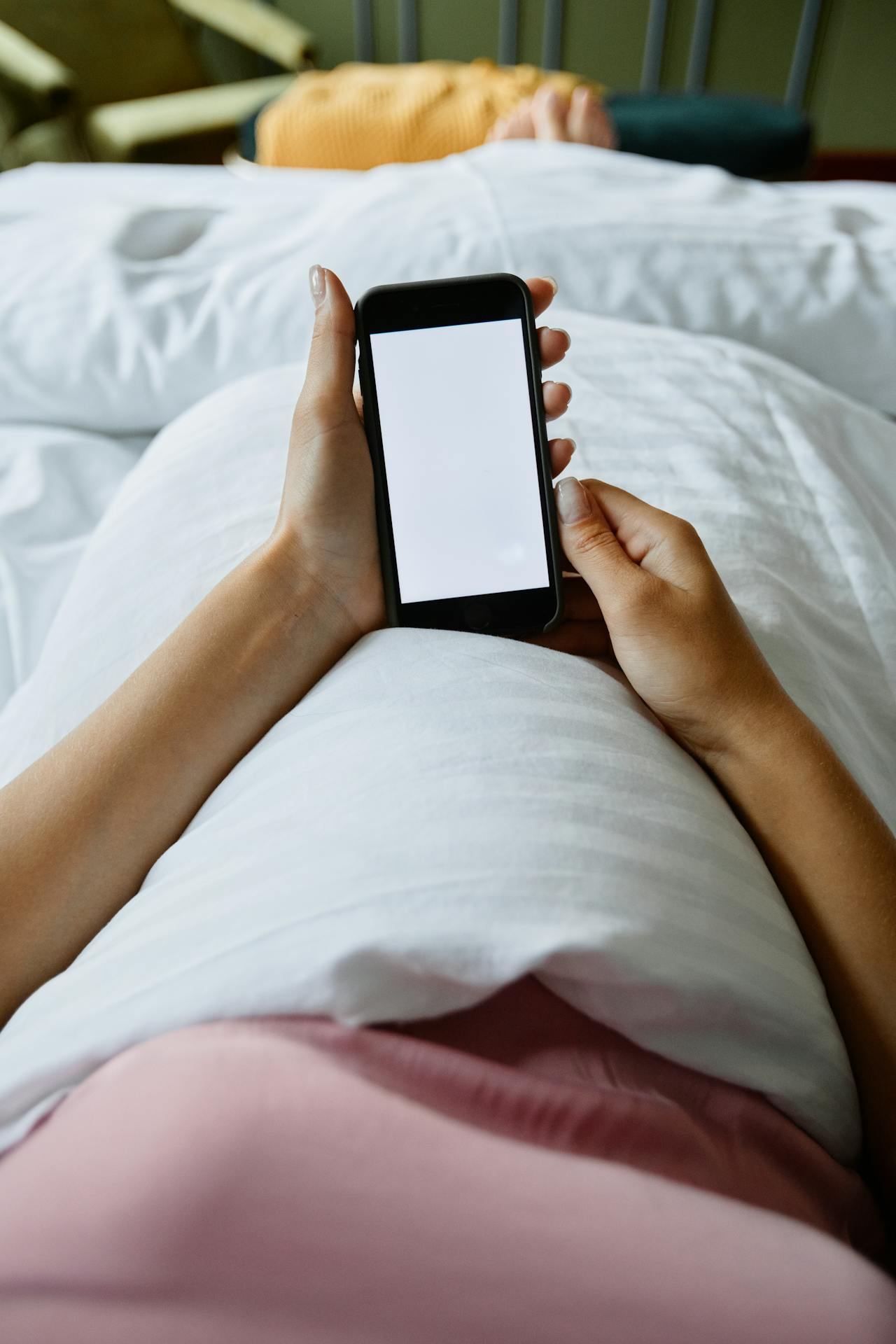 A woman using her phone in the bed | Source: Pexels