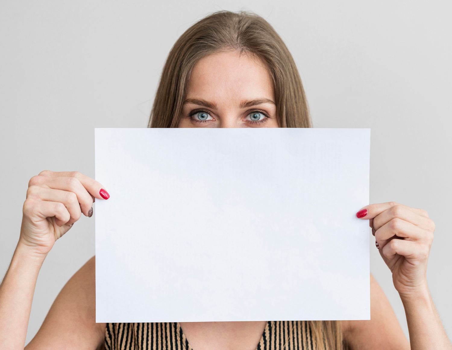 A woman holding a sheet of paper | Source: Freepik