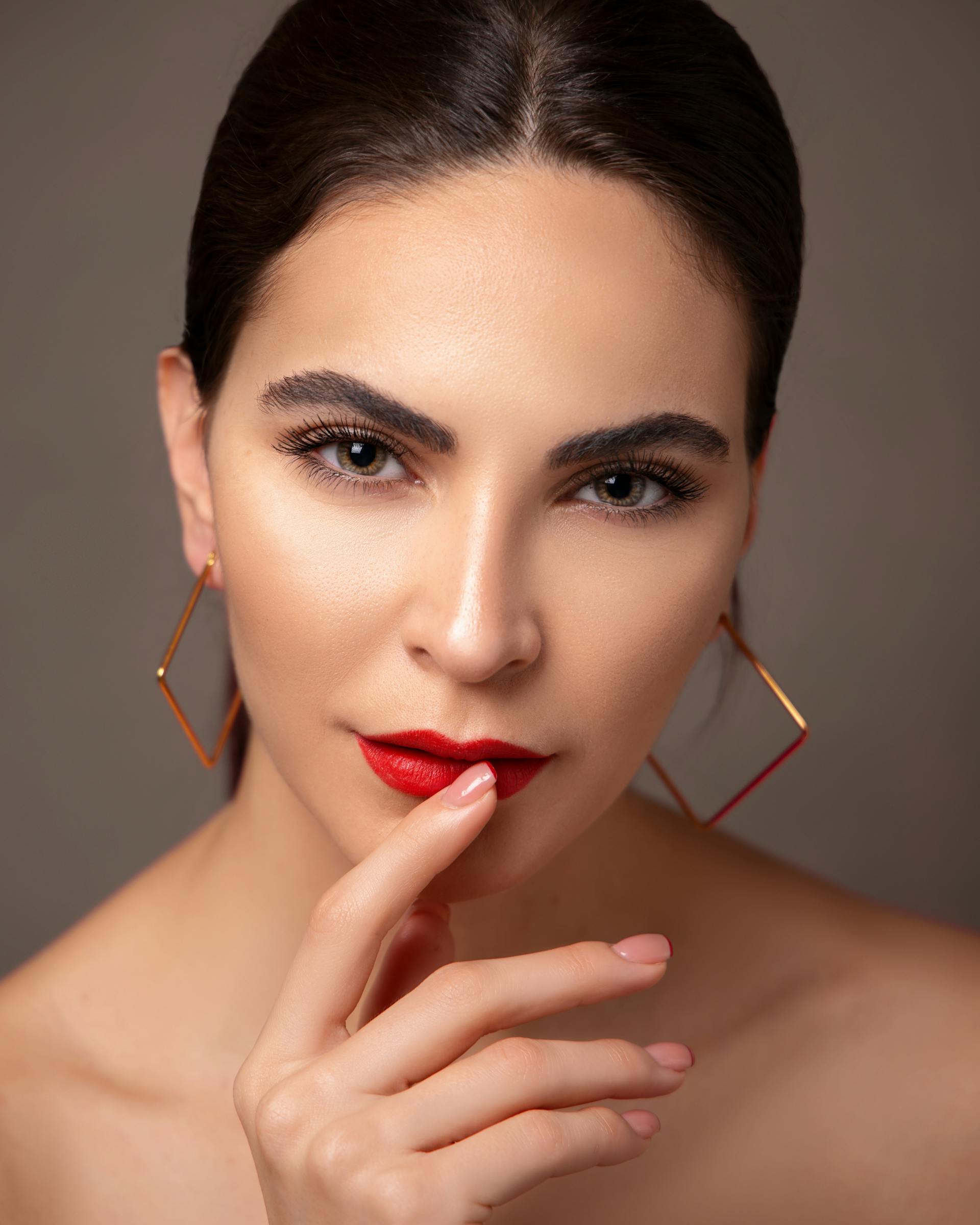 A woman wearing red lipstick and earrings | Source: Pexels