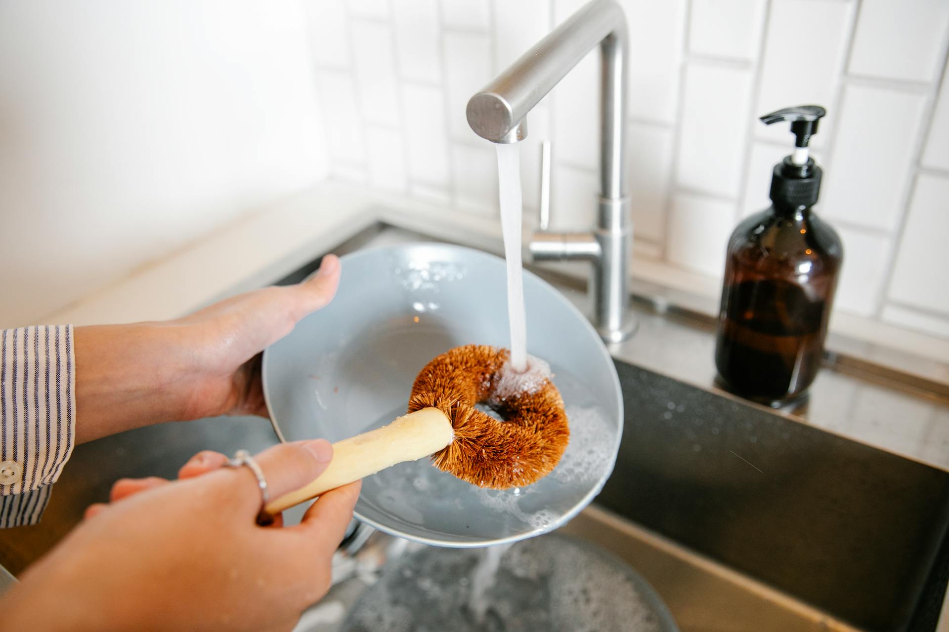 A woman washing dishes in the kitchen | Source: Pexels