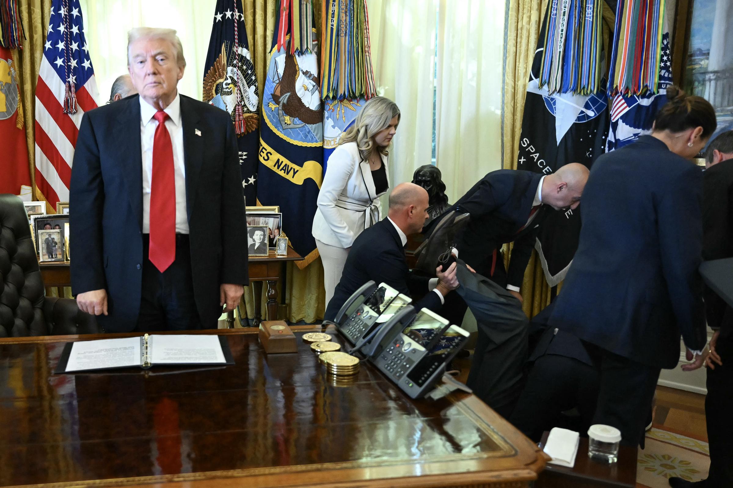 Donald Trump stands still after Gordon Findlay fainted in the Oval Office of the White House in Washington, DC, on November 6, 2025 | Source: Getty Images