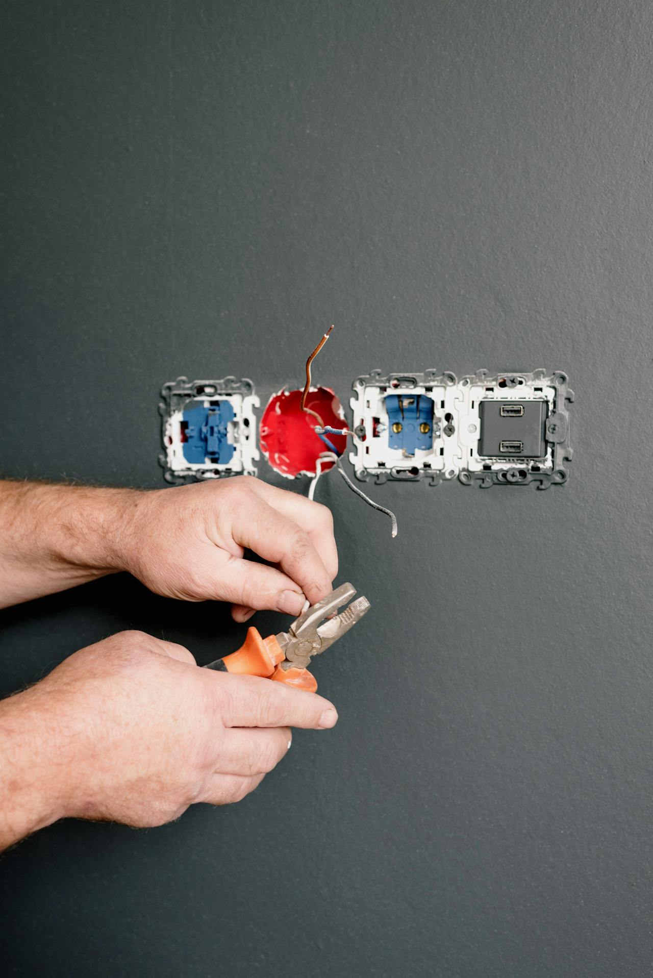 An electrician fixing AC power plugs and sockets | Source: Pexels
