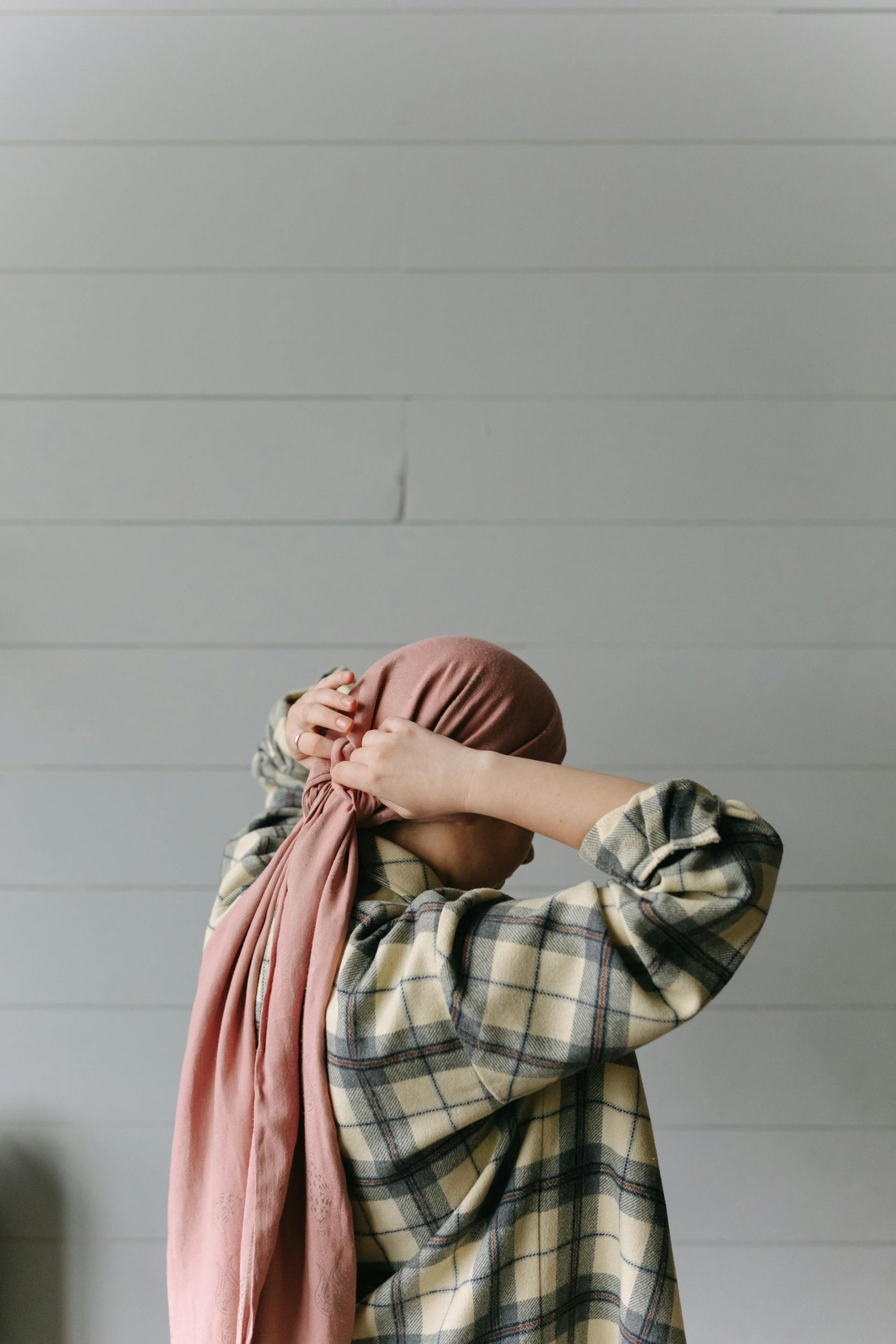 A woman putting on a headscarf | Source: Pexels