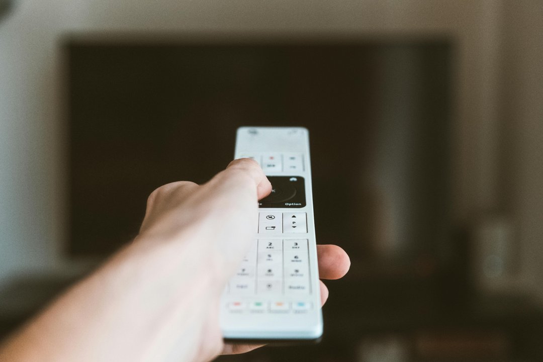 A man's hand holding a TV remote | Source: Pexels