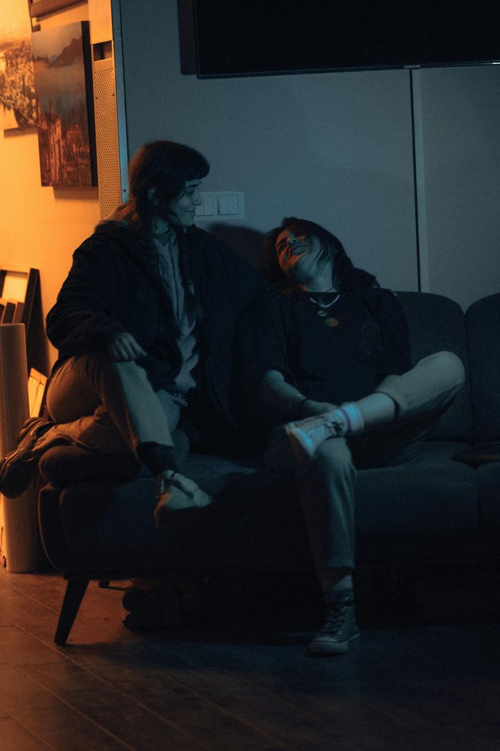 A couple sitting in a dark living room | Source: Pexels
