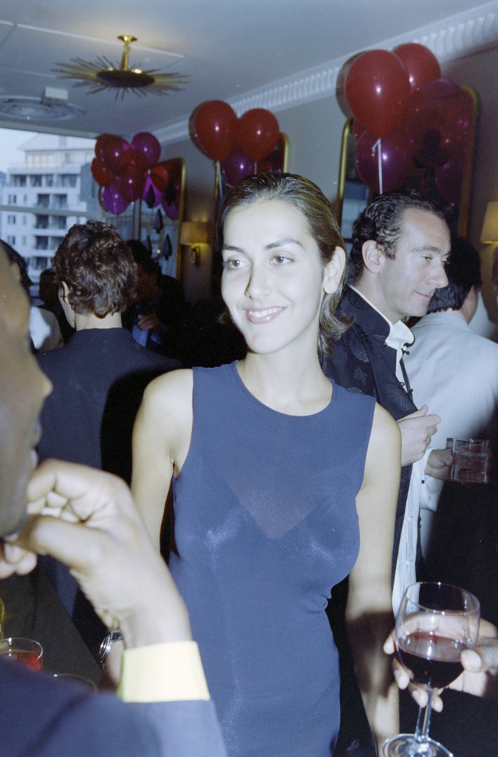 Natasha Caine and a guest attend a party in honor of David Tang, hosted by Michael and Shakira Caine, at The Canteen in London on June 20, 1997. She is smiling and appears to be enjoying herself as she chats with other attendees.